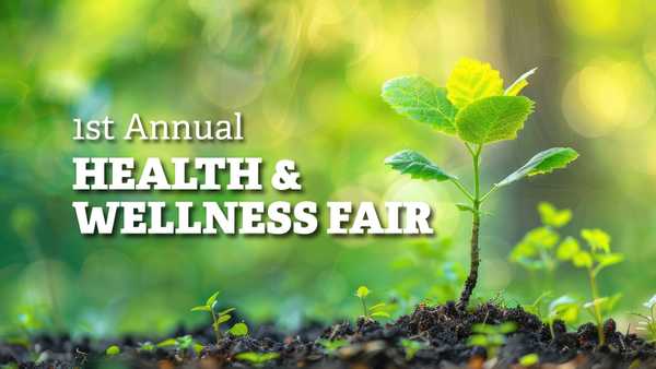 A seedling with bright yellow leaves grows from dark soil against a blurred green forest background. Bold white text on the left reads 1st Annual HEALTH & WELLNESS FAIR.